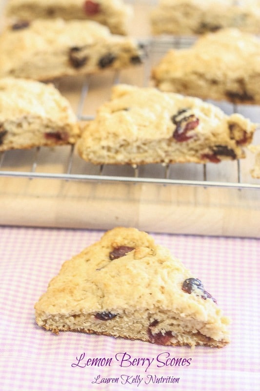 Lemon Berry Scones on a wire rack with one scone in front on a checkered towel.
