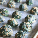 Spinach balls on a baking tray.