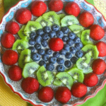 Vanilla chia pudding pie in a dish with fruit on top.