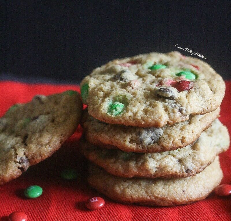 Close up stack of Christmas chocolate chip cookies on a red cloth.