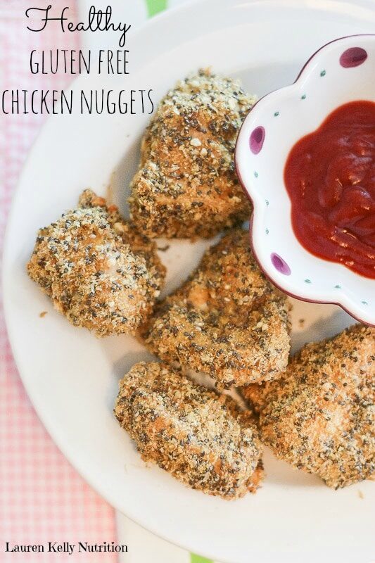 Healthy chicken nuggets on a plate with ketchup in a bowl.