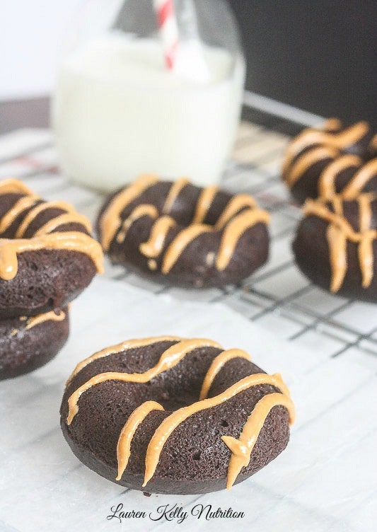 Dark Chocolate Donuts with Peanut Butter Glaze on parchment paper.