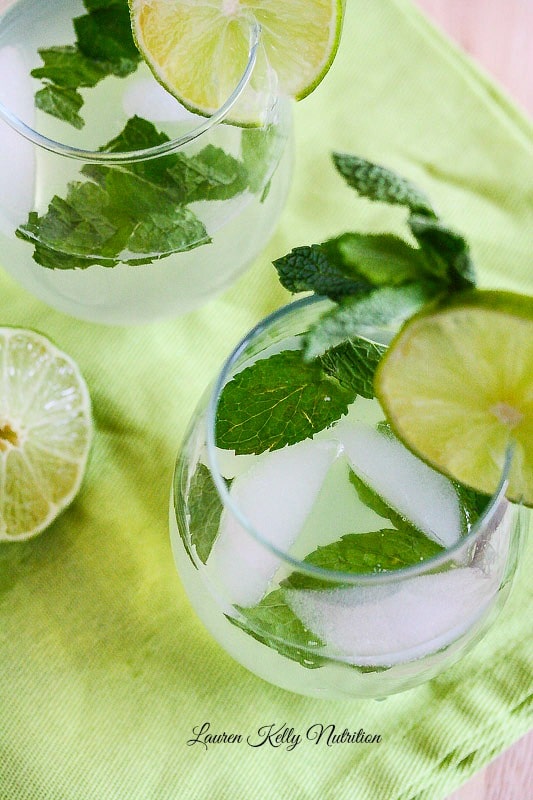 Overhead shot of mojito wine spritzer with mint leaves floating on top and a slice lime on the rim of the glass.