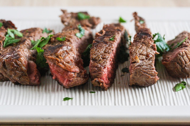 Horizontal view of sliced steak on platter.
