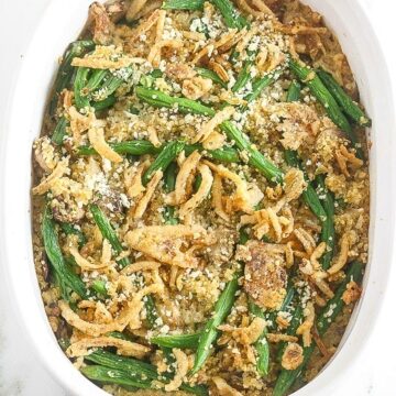 Overhead picture of cooked green bean casserole in a white baking dish.