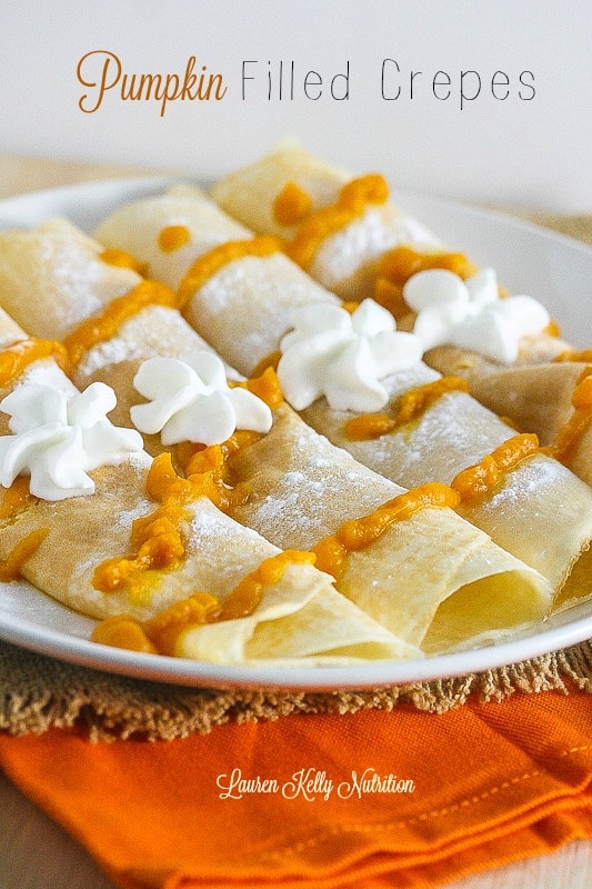 Pumpkin Crepes on a white plate with whipped topping.