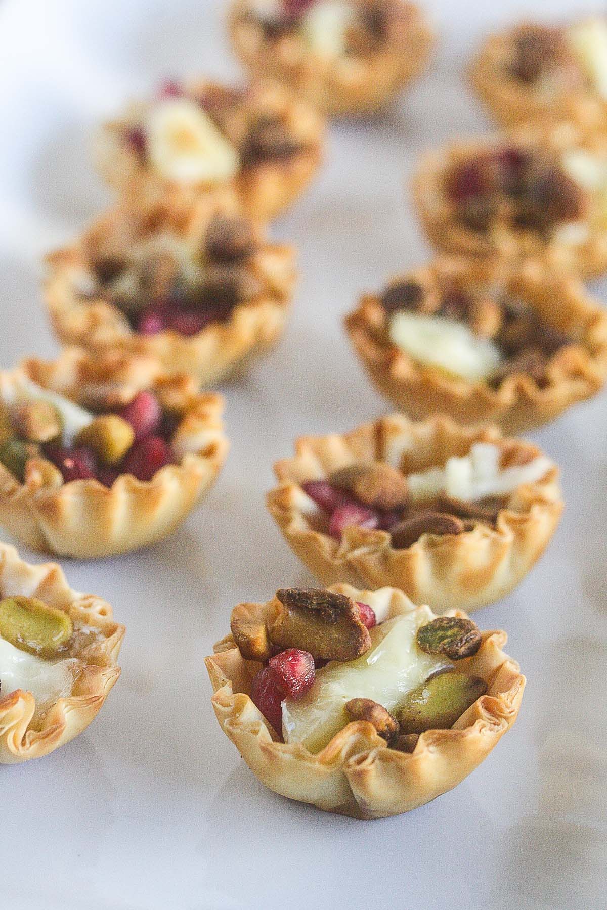 Four Ingredient Pomegranate Brie Phyllo Cups on a white background.