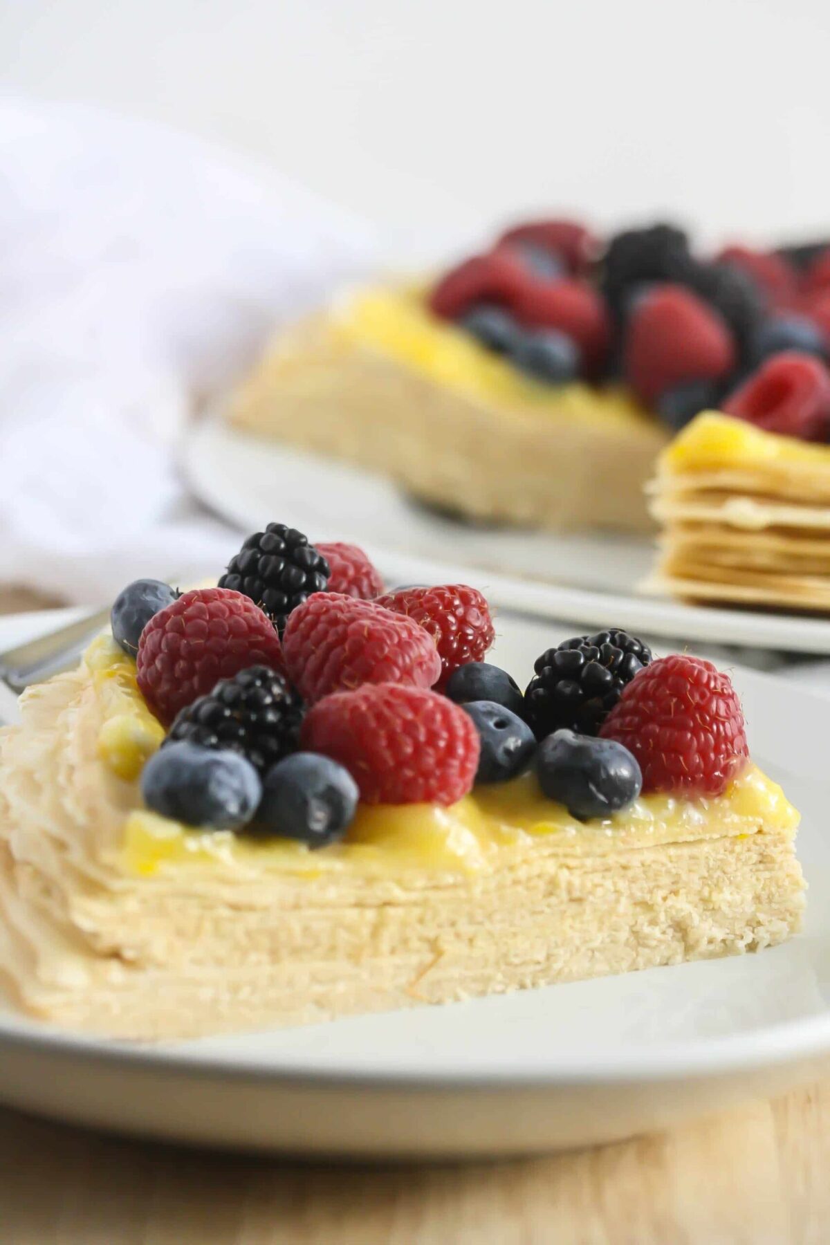 This Buttercream Crepe Cake with Lemon Curd is a decadent dessert that's lightened up and gluten-free.  And don't forget gorgeous! Each delicious crepe is layered with buttercream and topped with tangy lemon curd! 