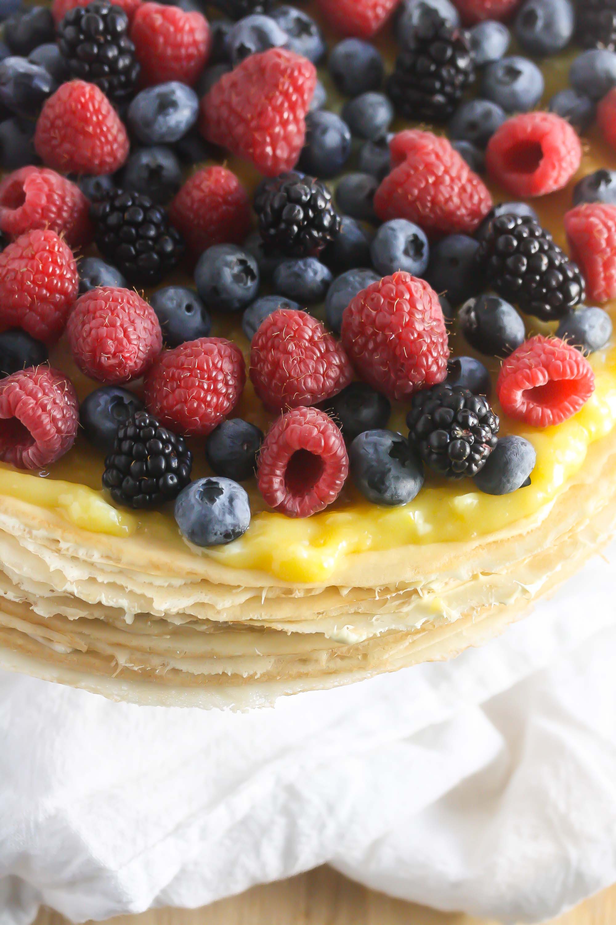 Close up of berries on Gluten-Free Buttercream Crepe Cake with Lemon Curd Topping