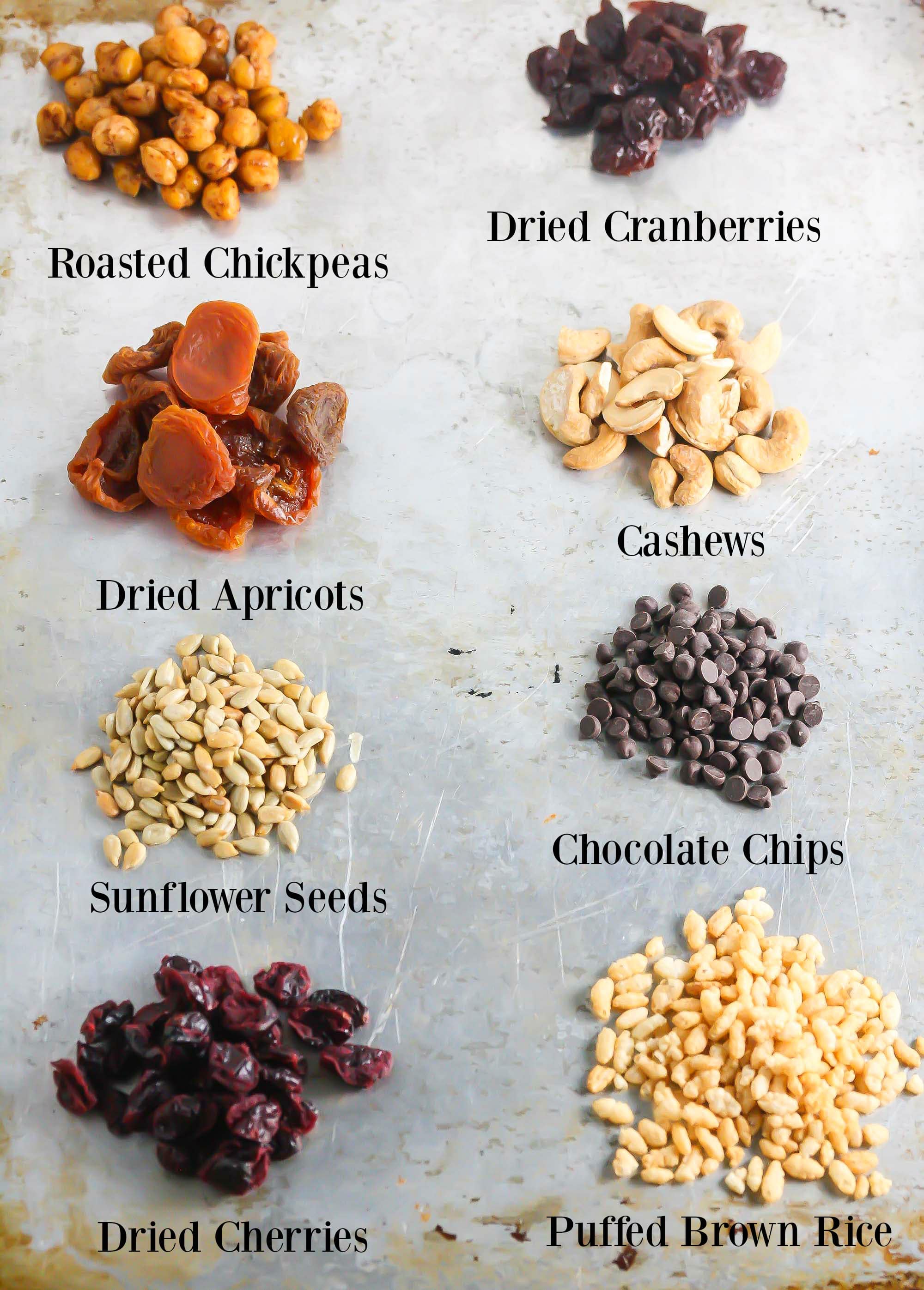 Roasted chickpea trail mix all ingredients individually on a pan with names under it.