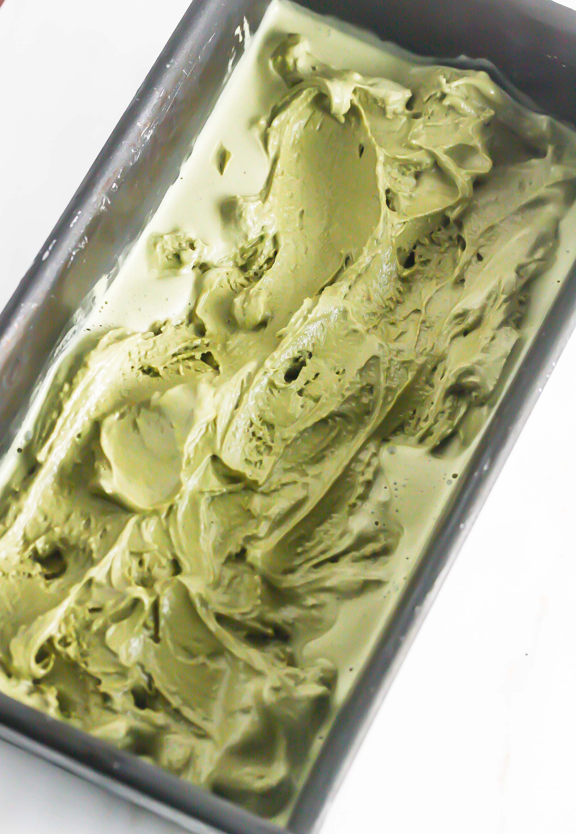 Overhead diagonal picture of matcha ice cream in a rectangular baking dish.