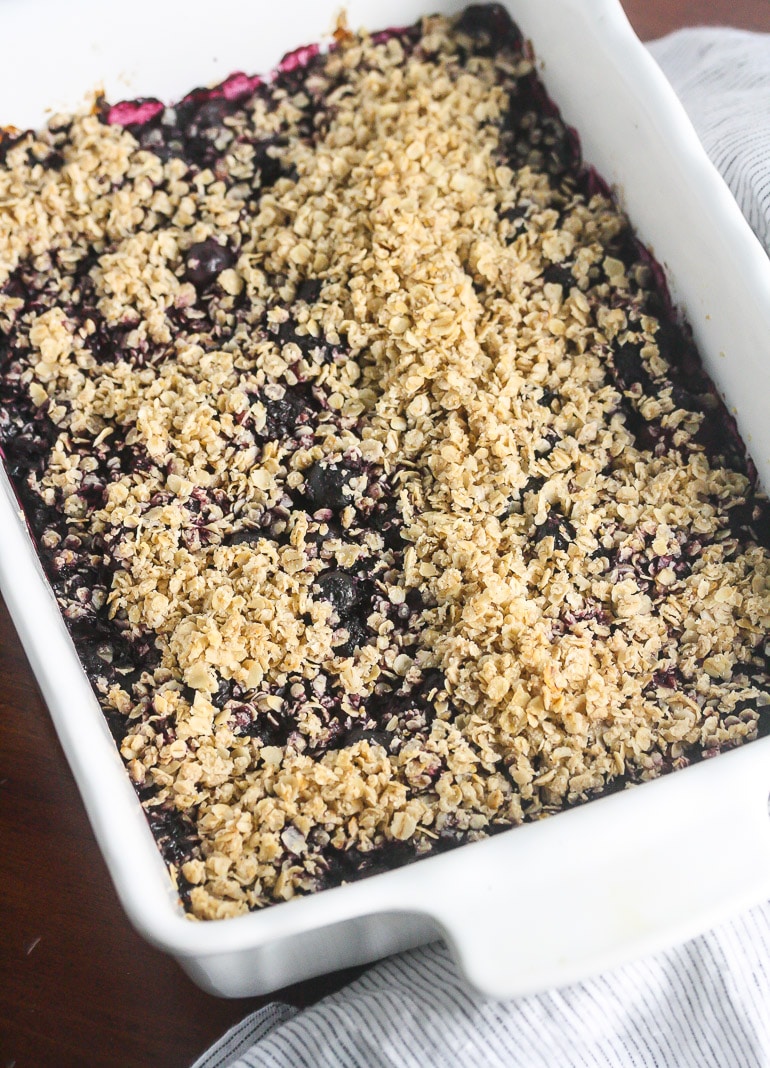 Oat topping on top of berries in dish.