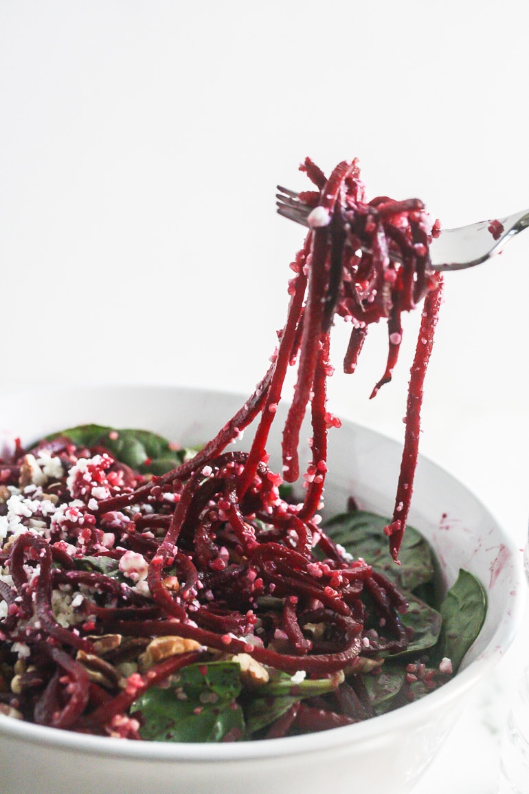 Close up of Spiralized Beet Quinoa Salad with beet strings on a fork.