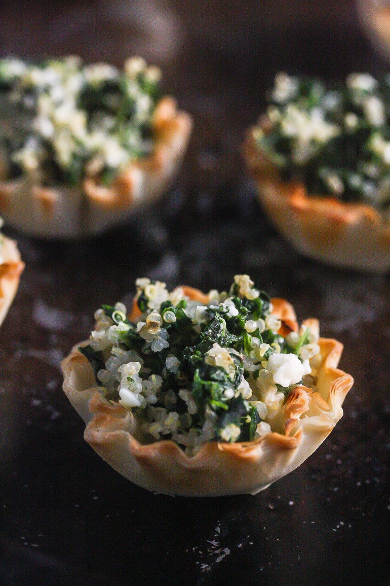 Close up Spinach Phyllo Bites on a dark baking tray.