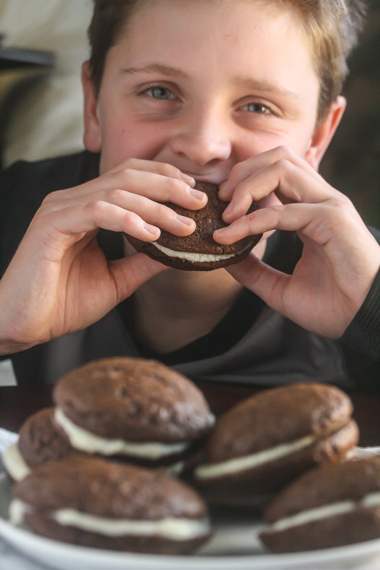 Ben holding Whoopie Pies and taking a bite of one.