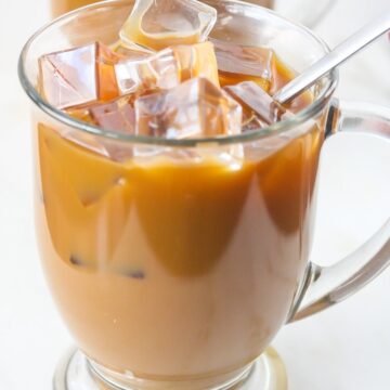 Close up of Iced Mocha Latte with ice cubes in a clear mug.