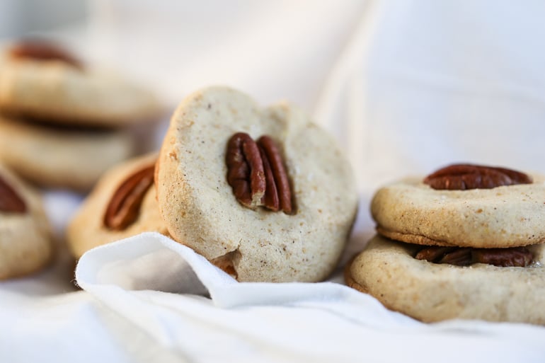 Butter Pecan Cookies are draped on a white cloth.