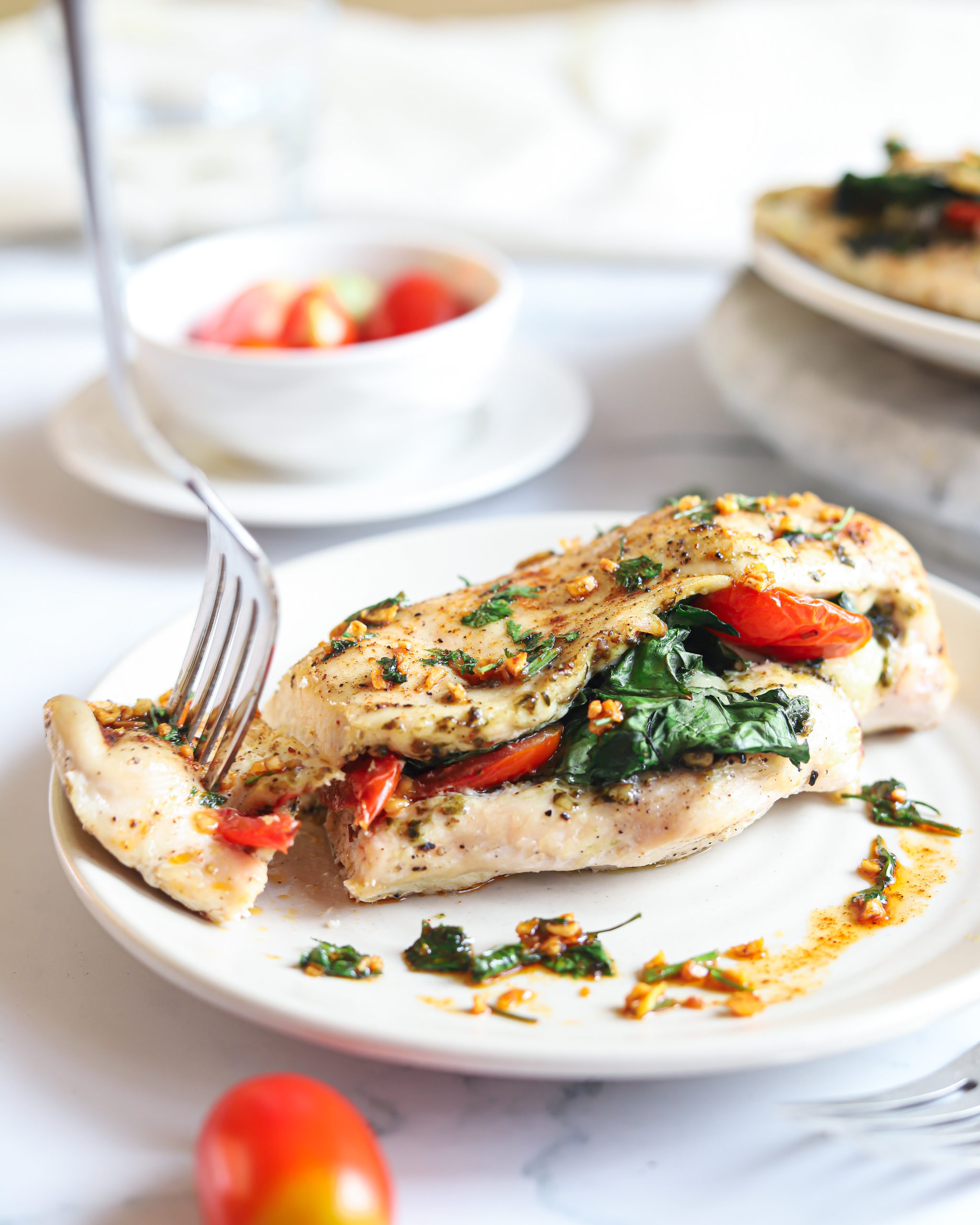 Cheesy Pesto Spinach Stuffed Chicken Breasts on a white plate.