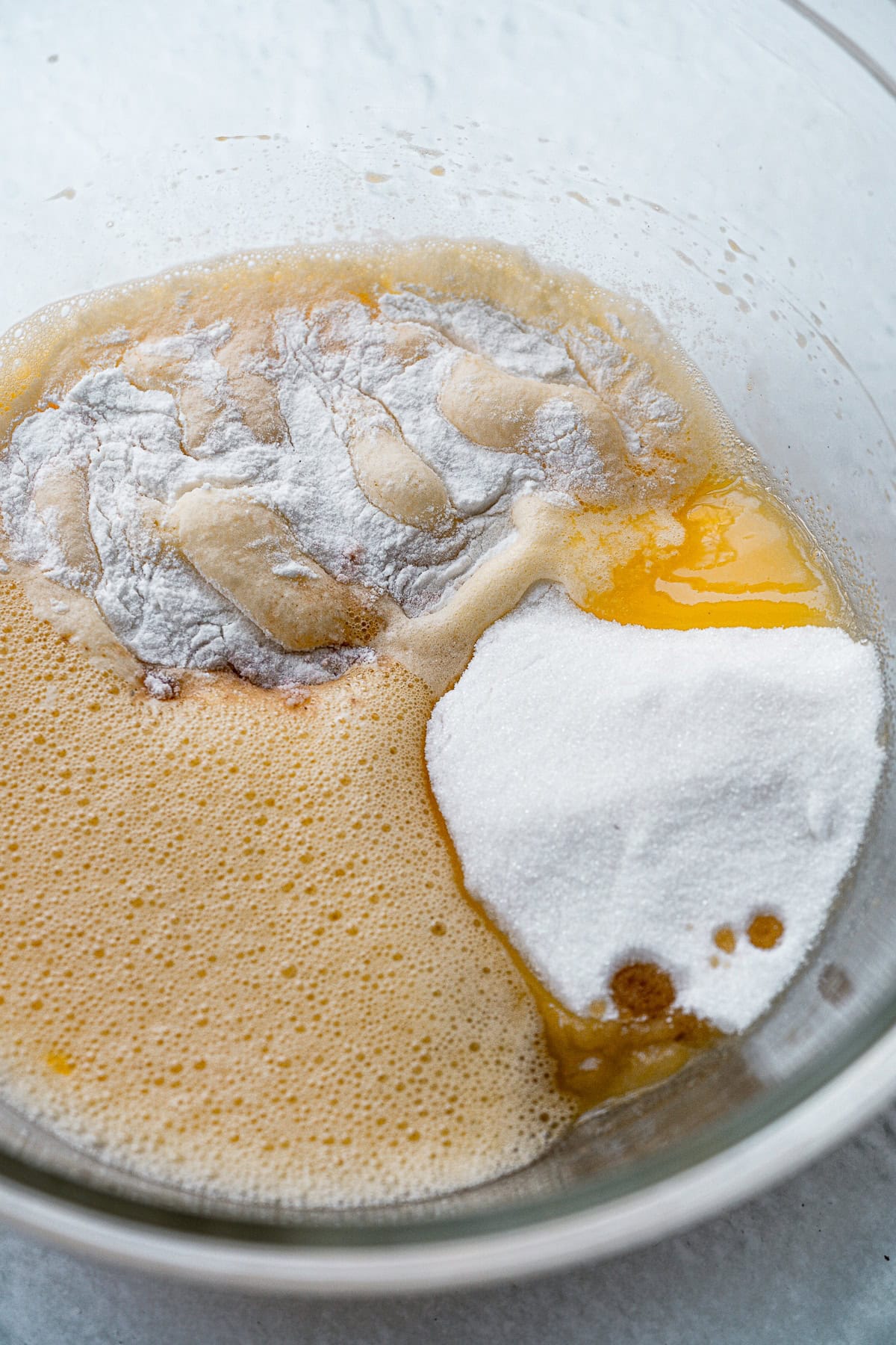 Overhead picture of wet and dry ingredients in a glass bowl.