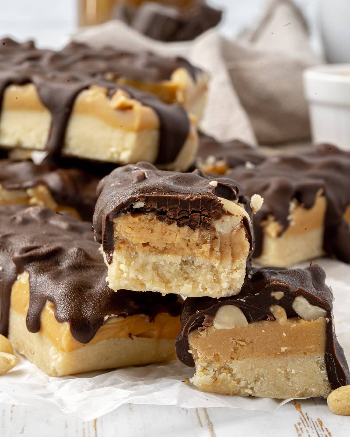 Close up picture of snickers bars and the one in the front has a bite in it.