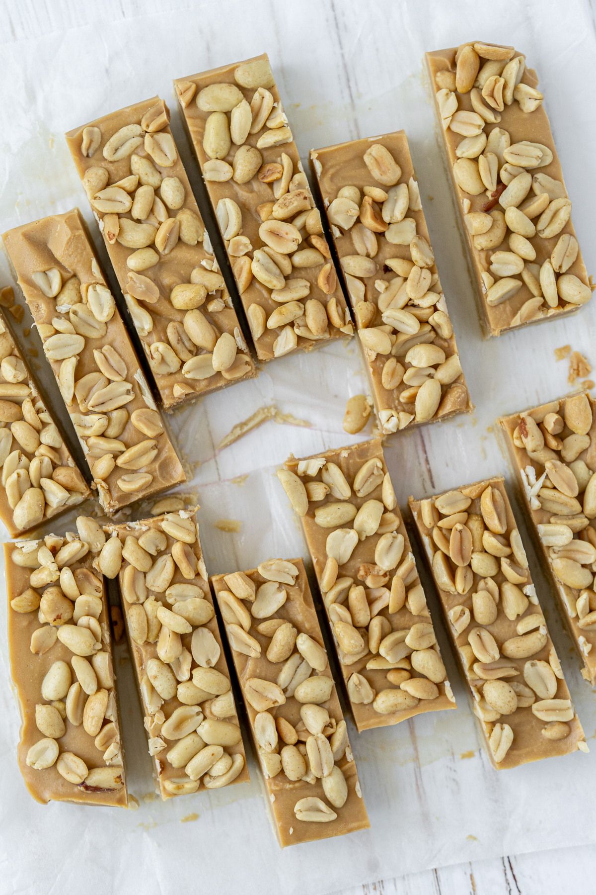 Overhead view of sliced bars with peanut butter and peanut layers without the chocolate drizzle.
