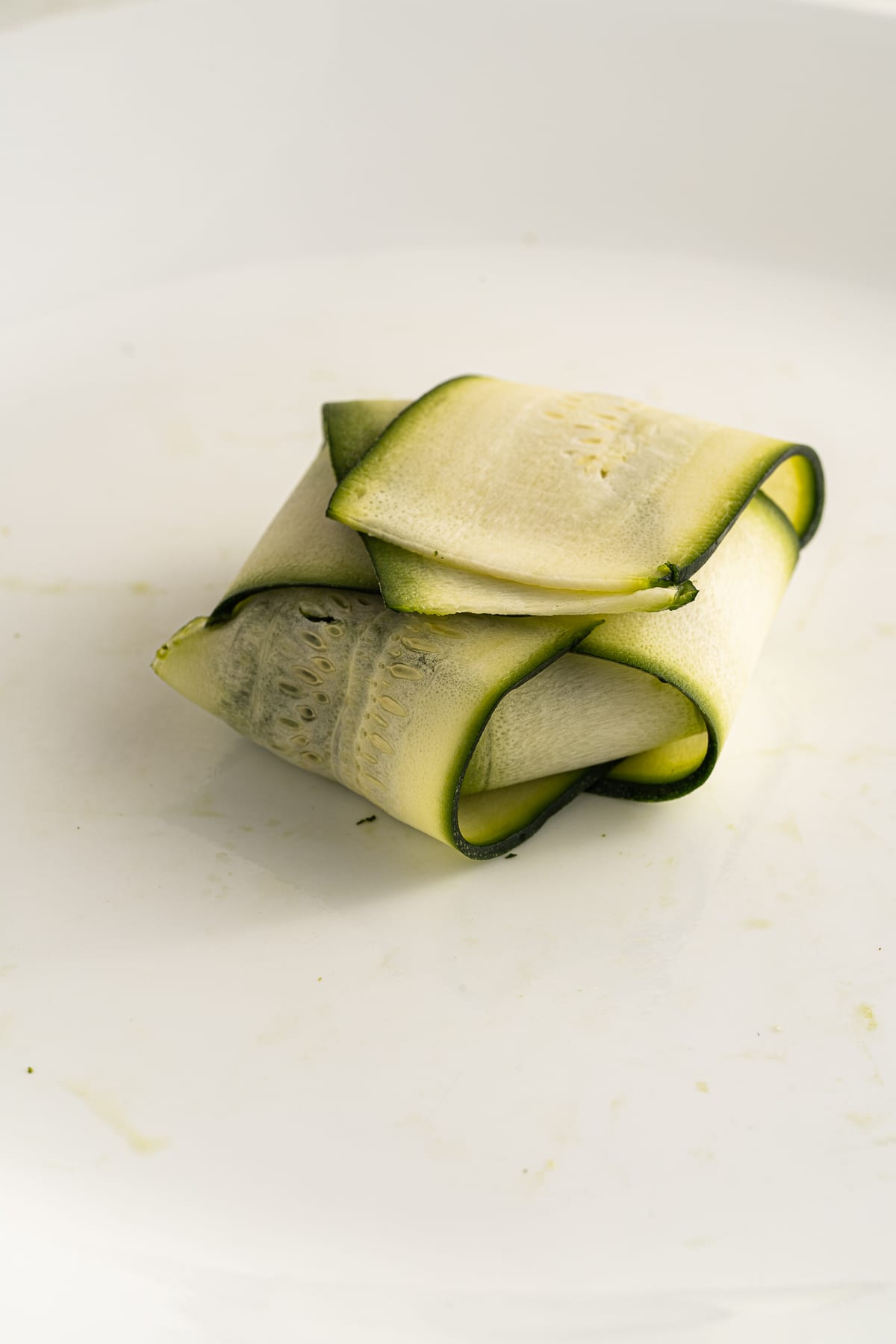 Picture of folded zucchini ravioli wit spinach cheese mixture in the middle.