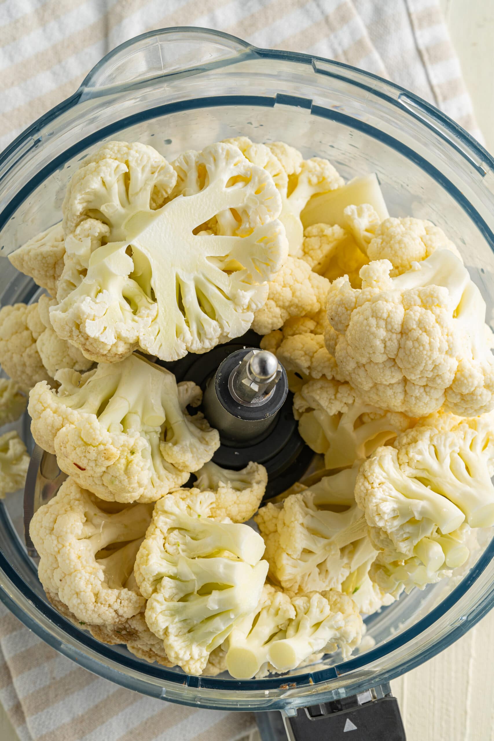 Close up picture of cauliflower florets in food processor.
