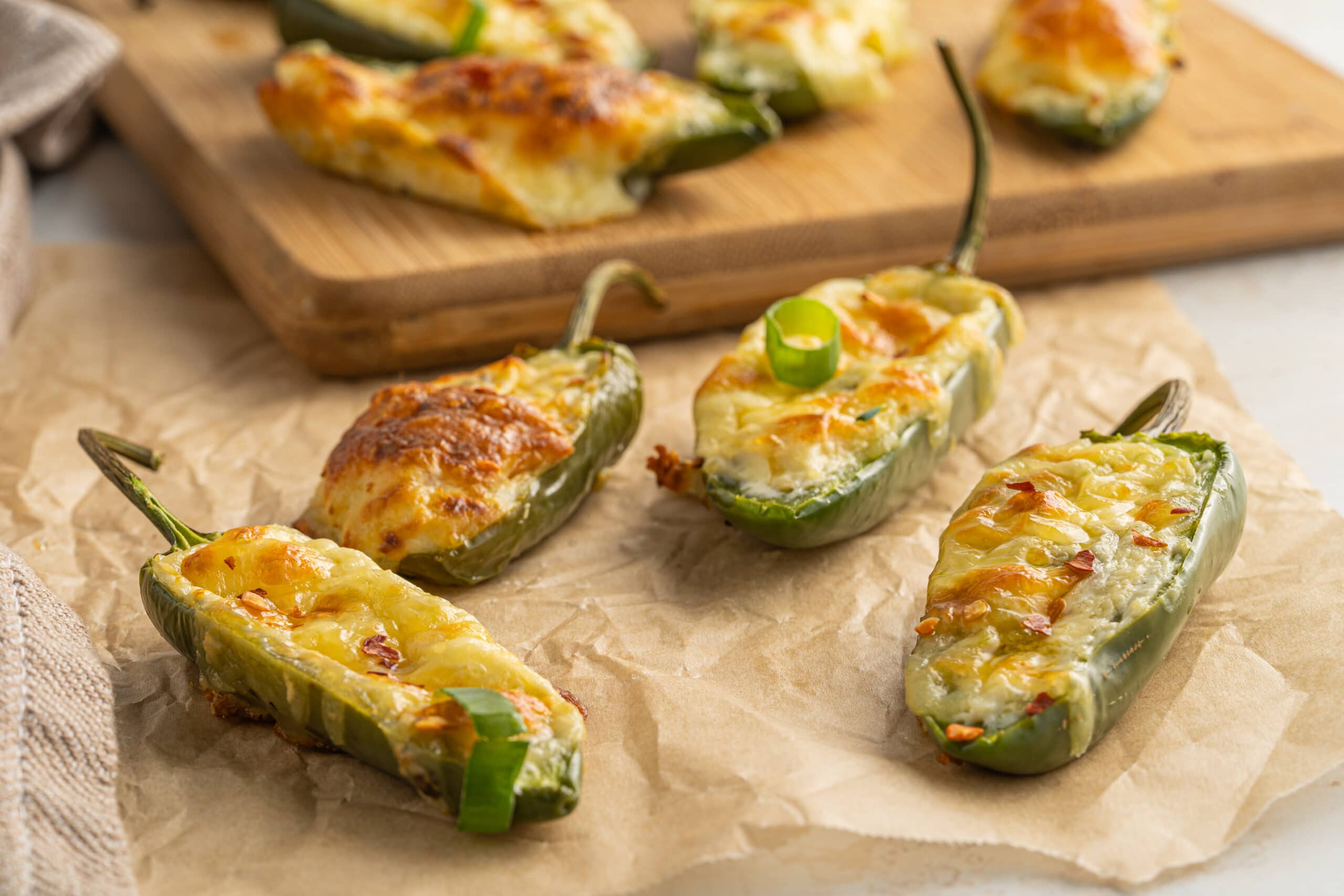 Horizontal picture of finished jalapeño poppers recipe on parchment paper.