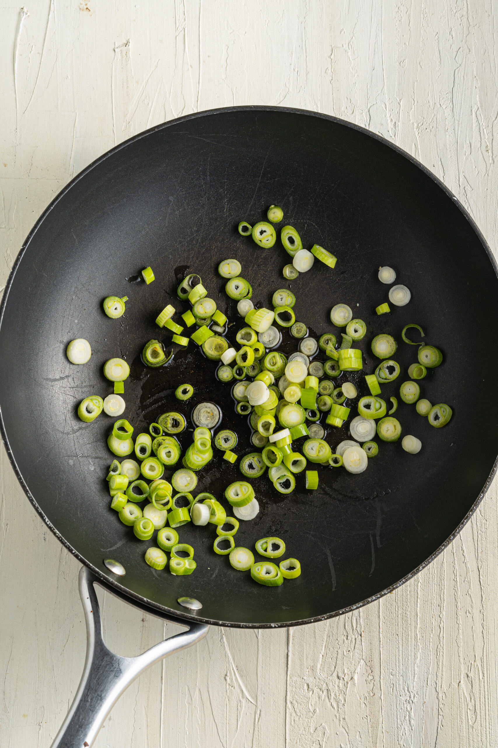 Chopped green onion in a skillet.