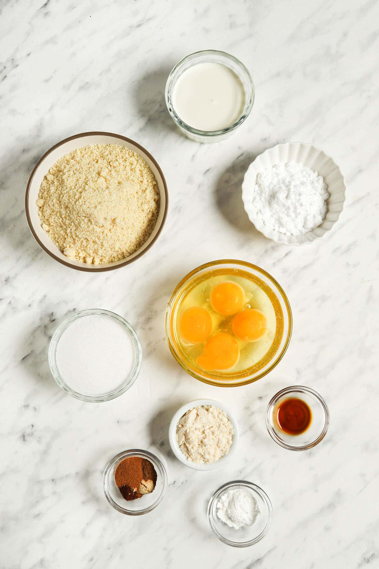 Ingredients for gingerbread cake on a white background in individual clear bowls.