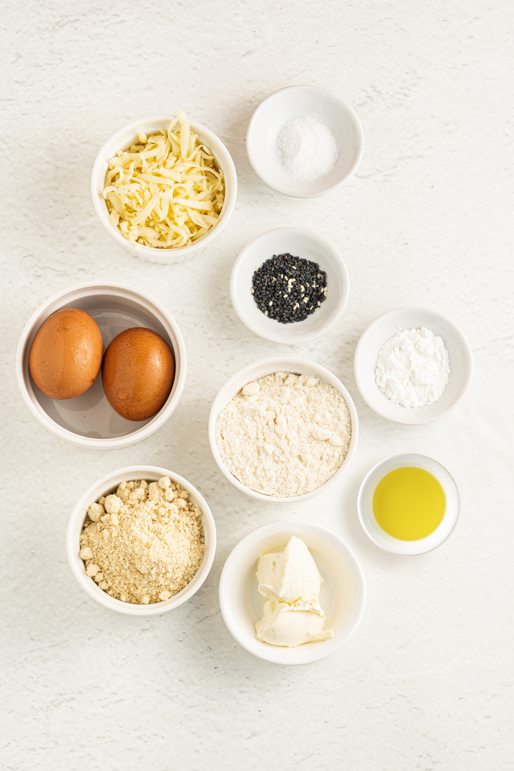 Ingredients for low carb rolls in individual hall white bowls.