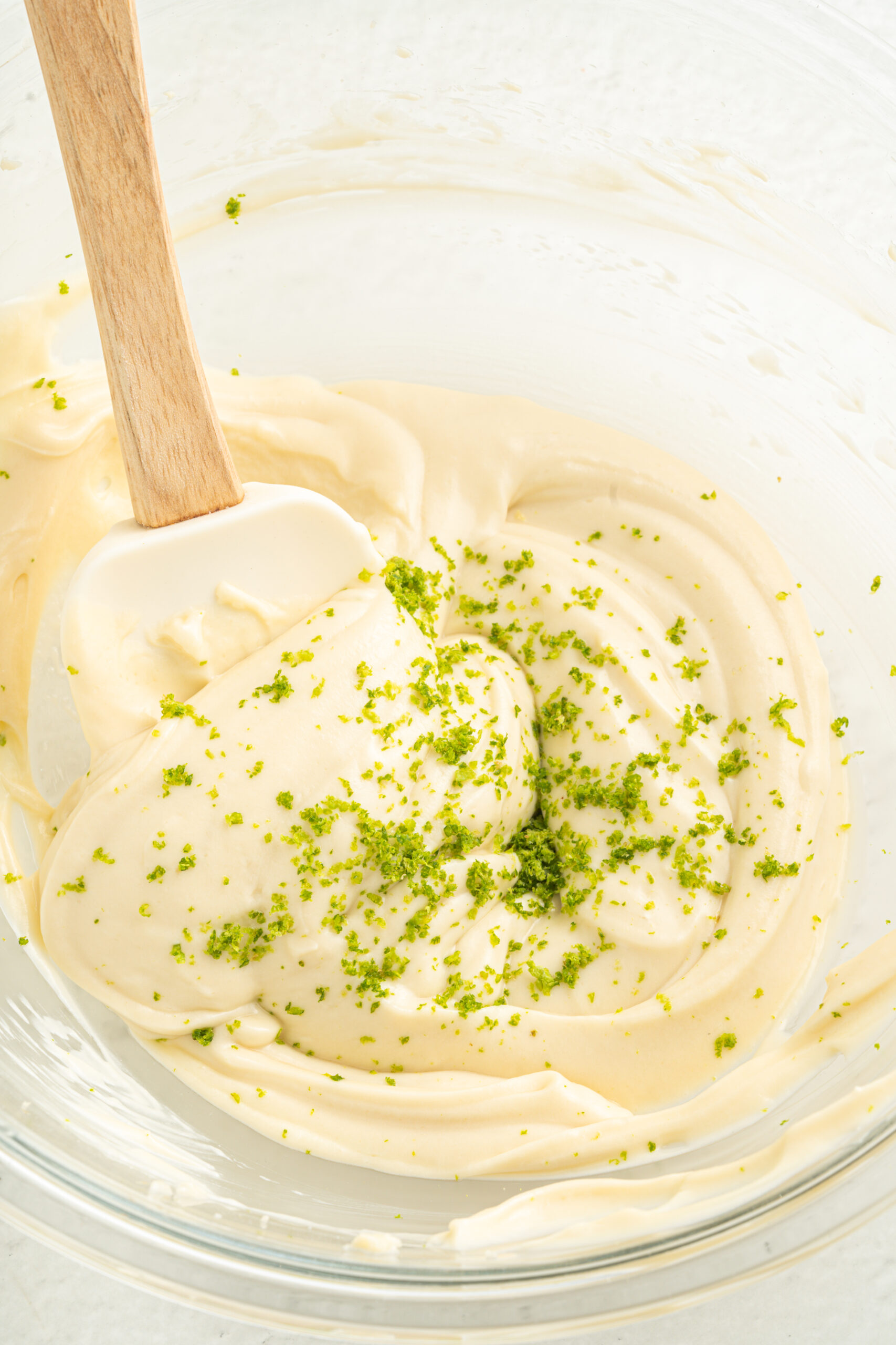 Whipped cream cheese mixture with lime zest in mixing bowl.