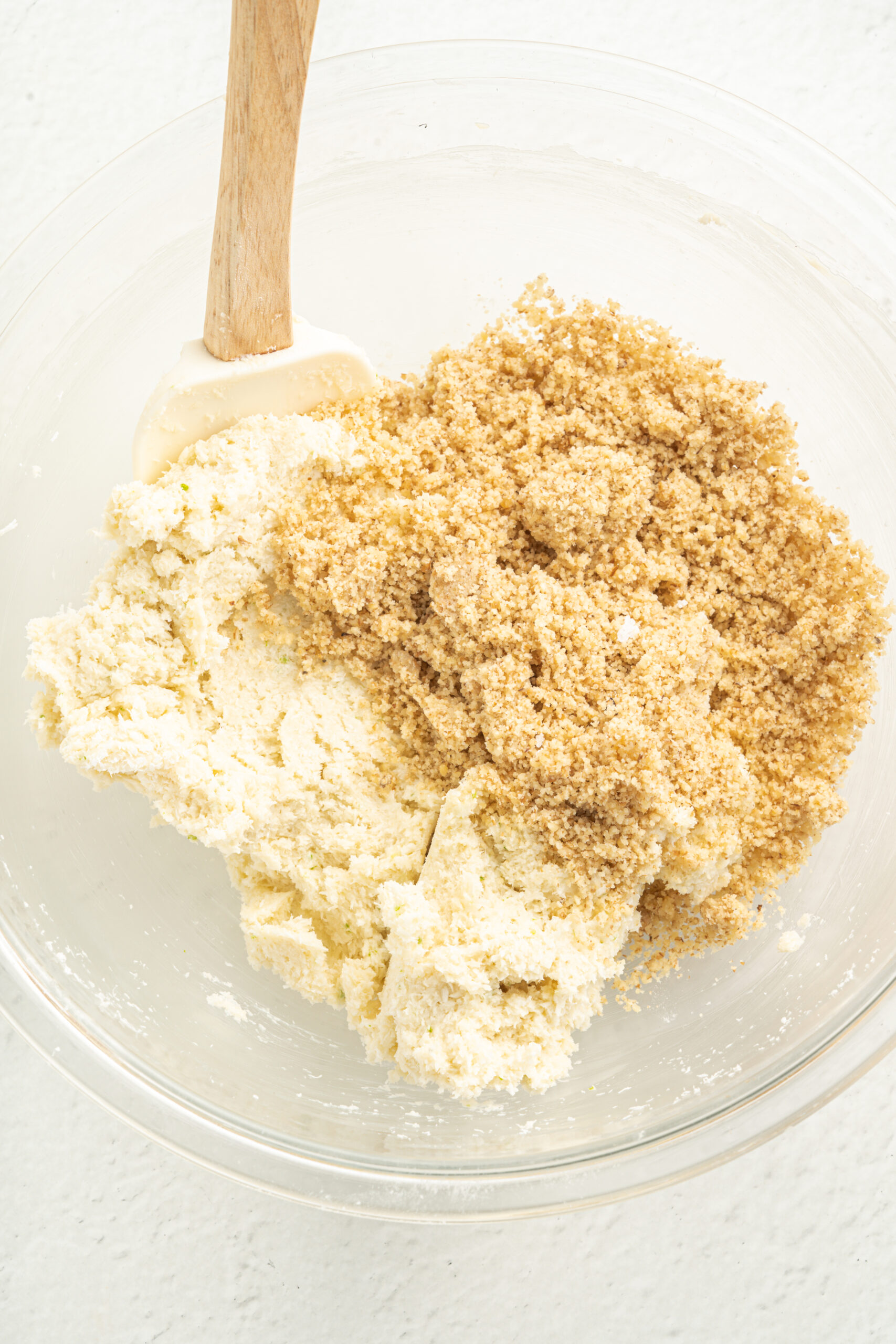 Cream cheese mixture with ground walnuts in mixing bowl.