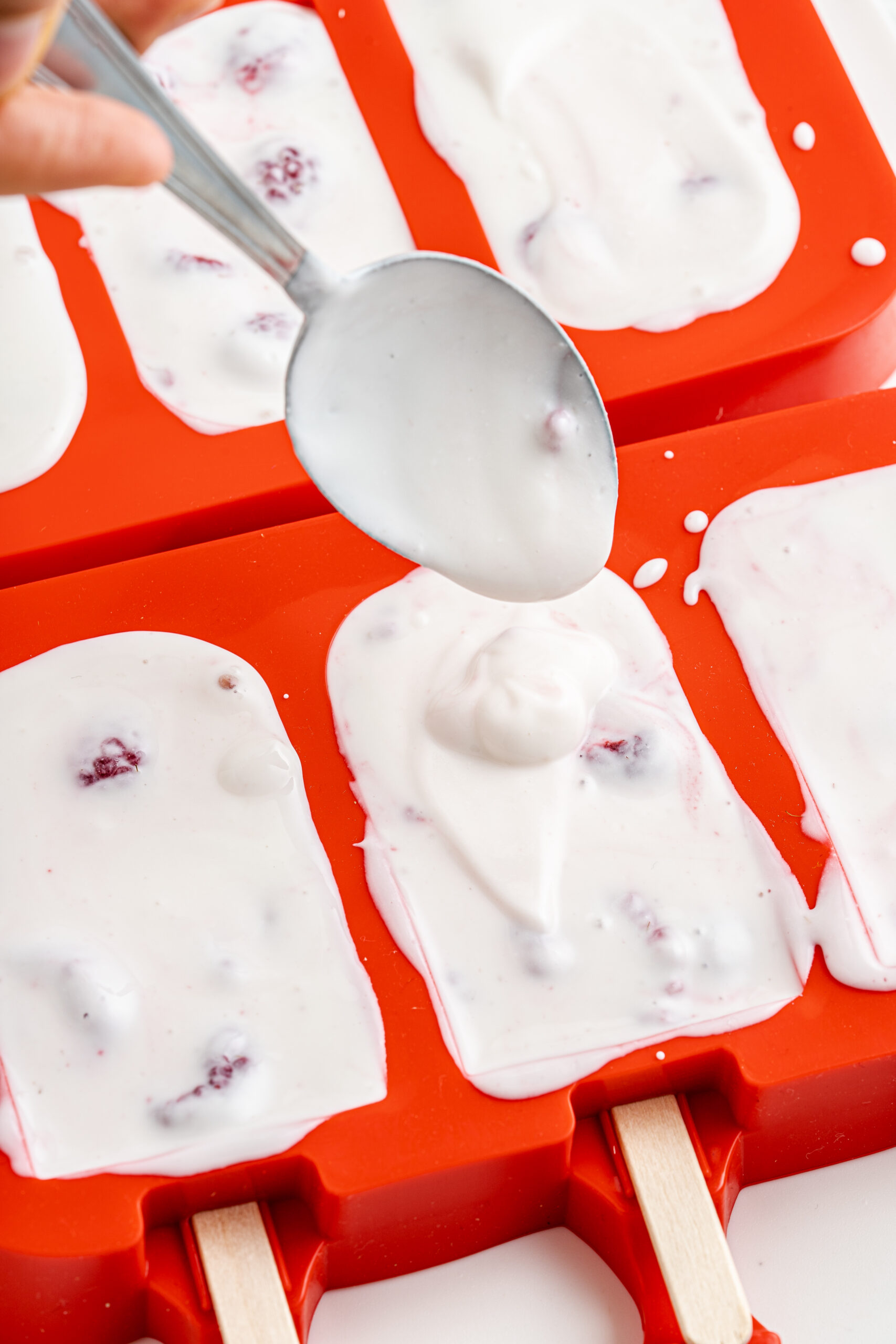 Raspberry Yogurt Popsicles in molds.