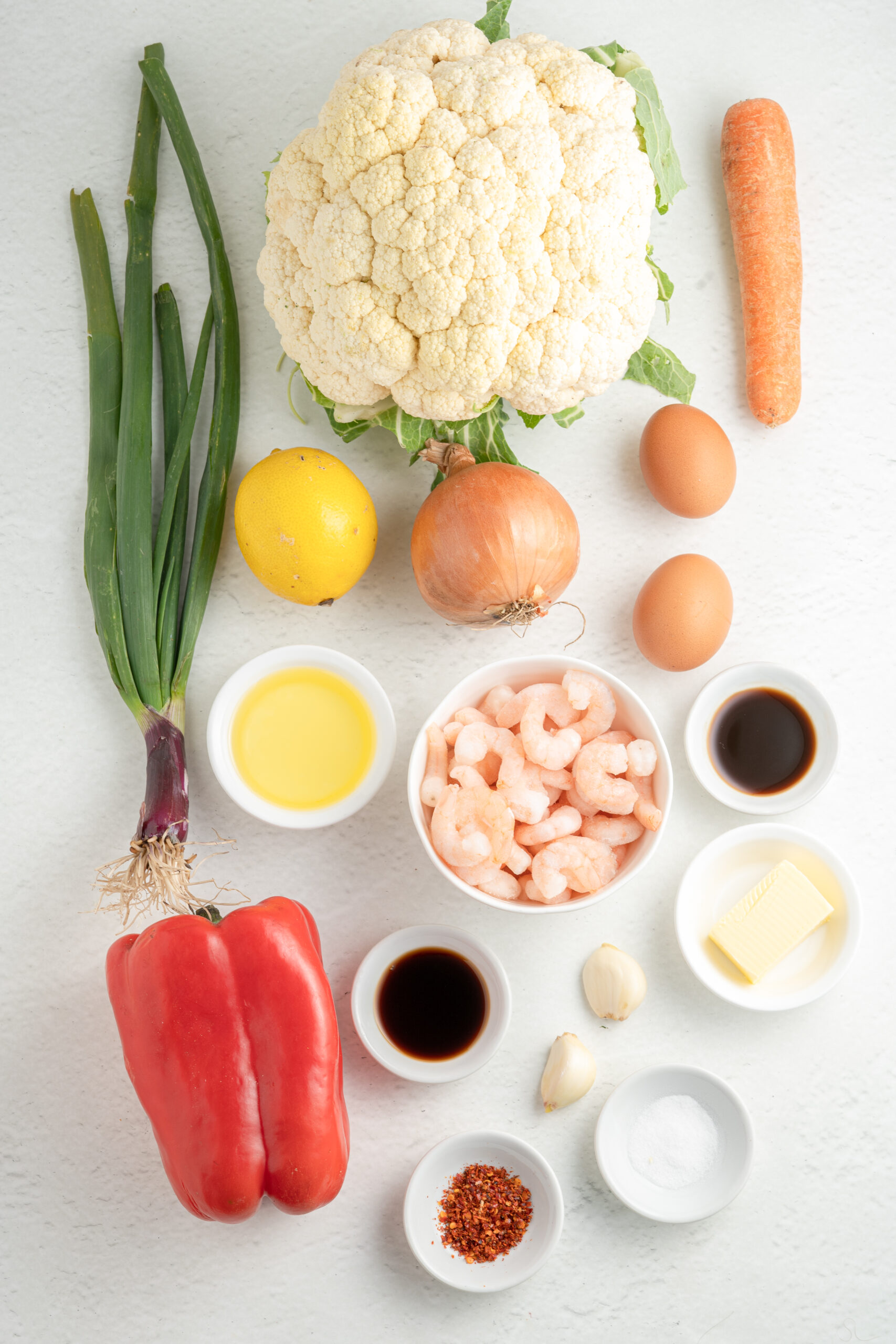Ingredients for Shrimp Fried Cauliflower Rice in individual white bowls.