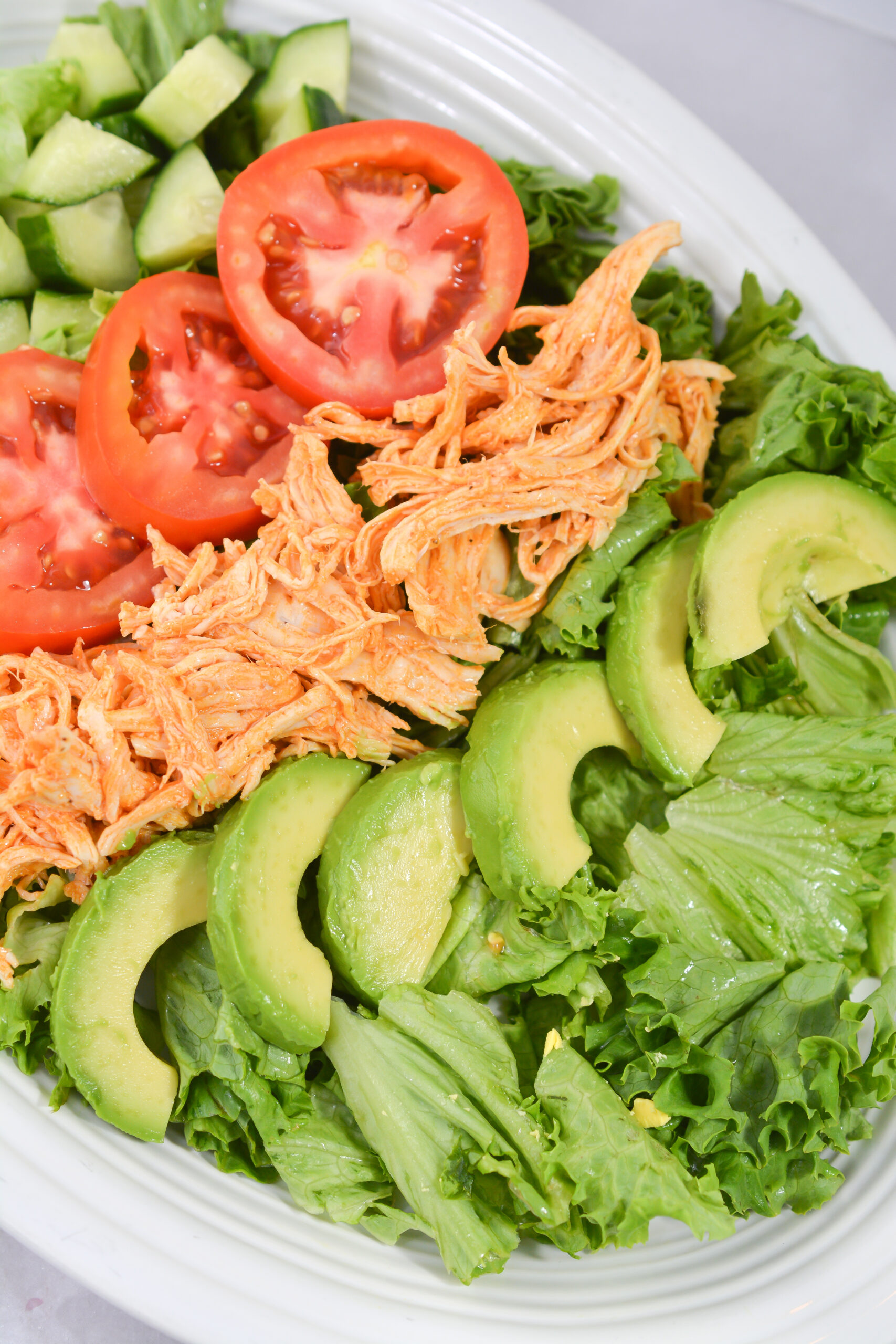 Buffalo Chicken Cobb Salad without dressing on a white plate.