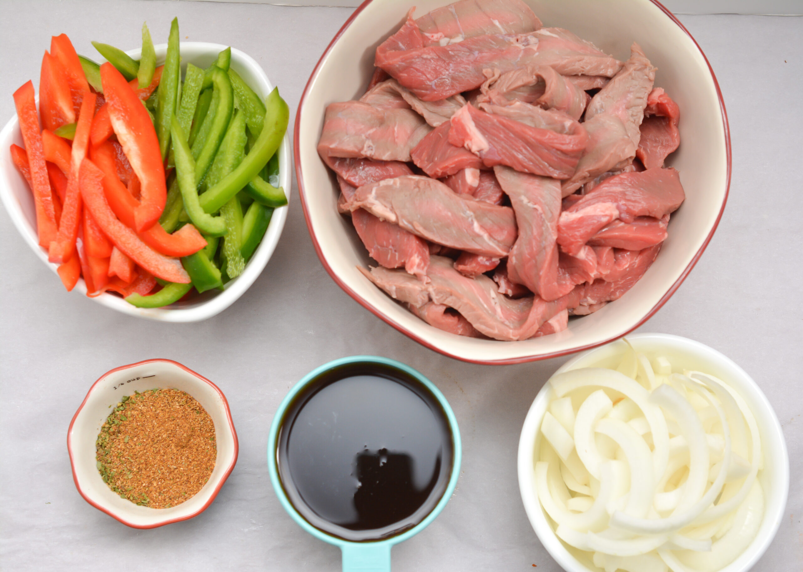 Ingredients for steak fajitas in individual bowls.