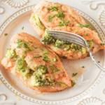 Broccoli stuffed chicken cut in the middle on a plate.