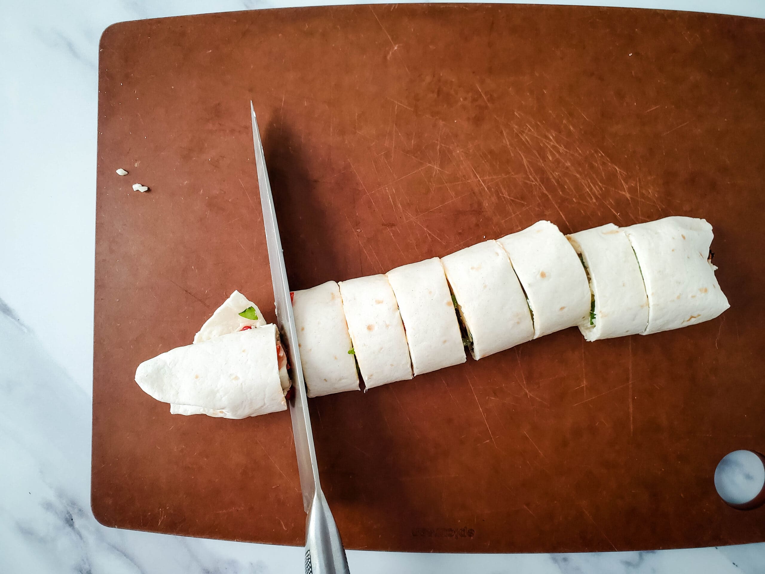 Slicing tortillas on a cutting board.