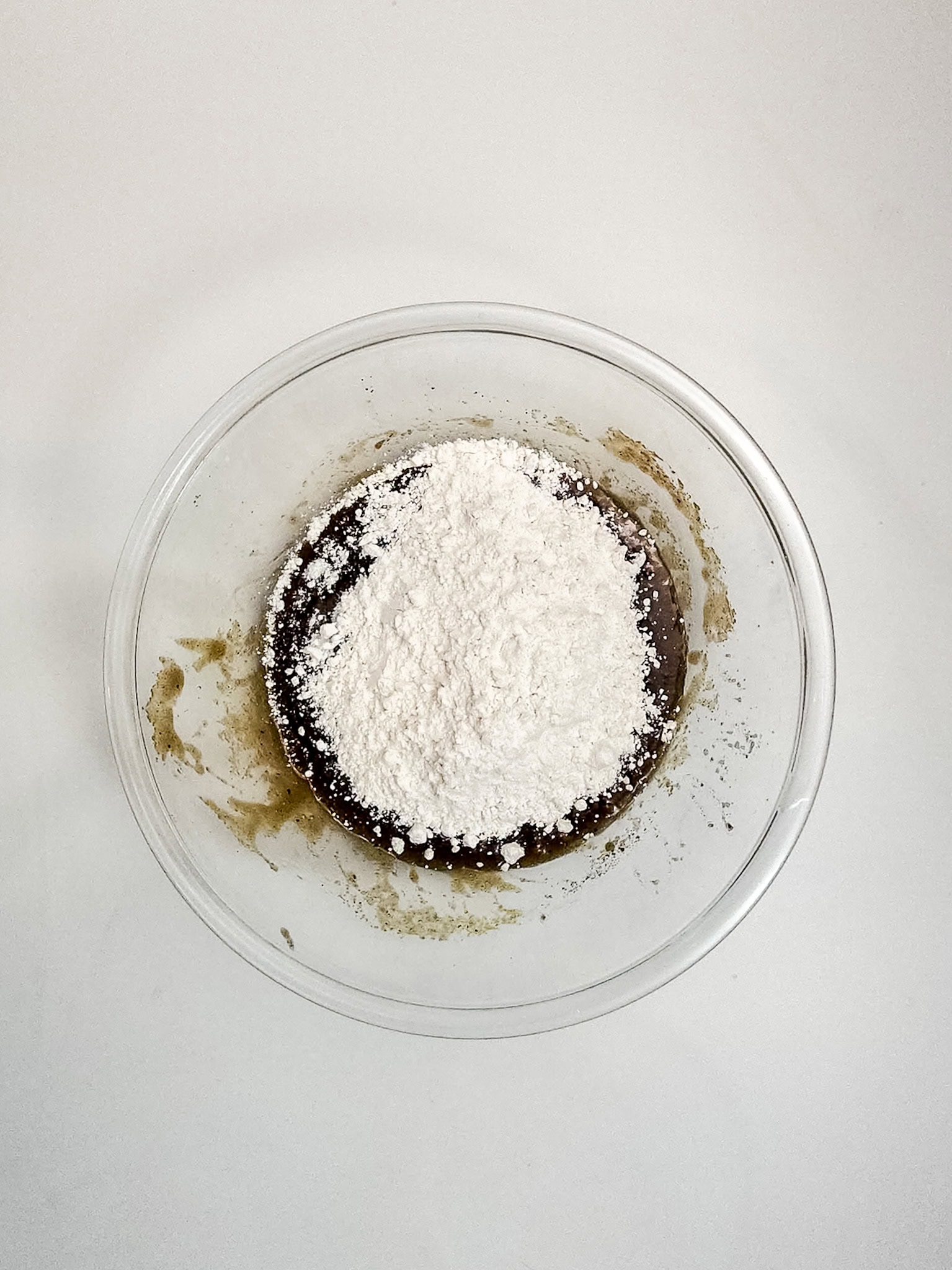 Adding in flour to glass bowl.
