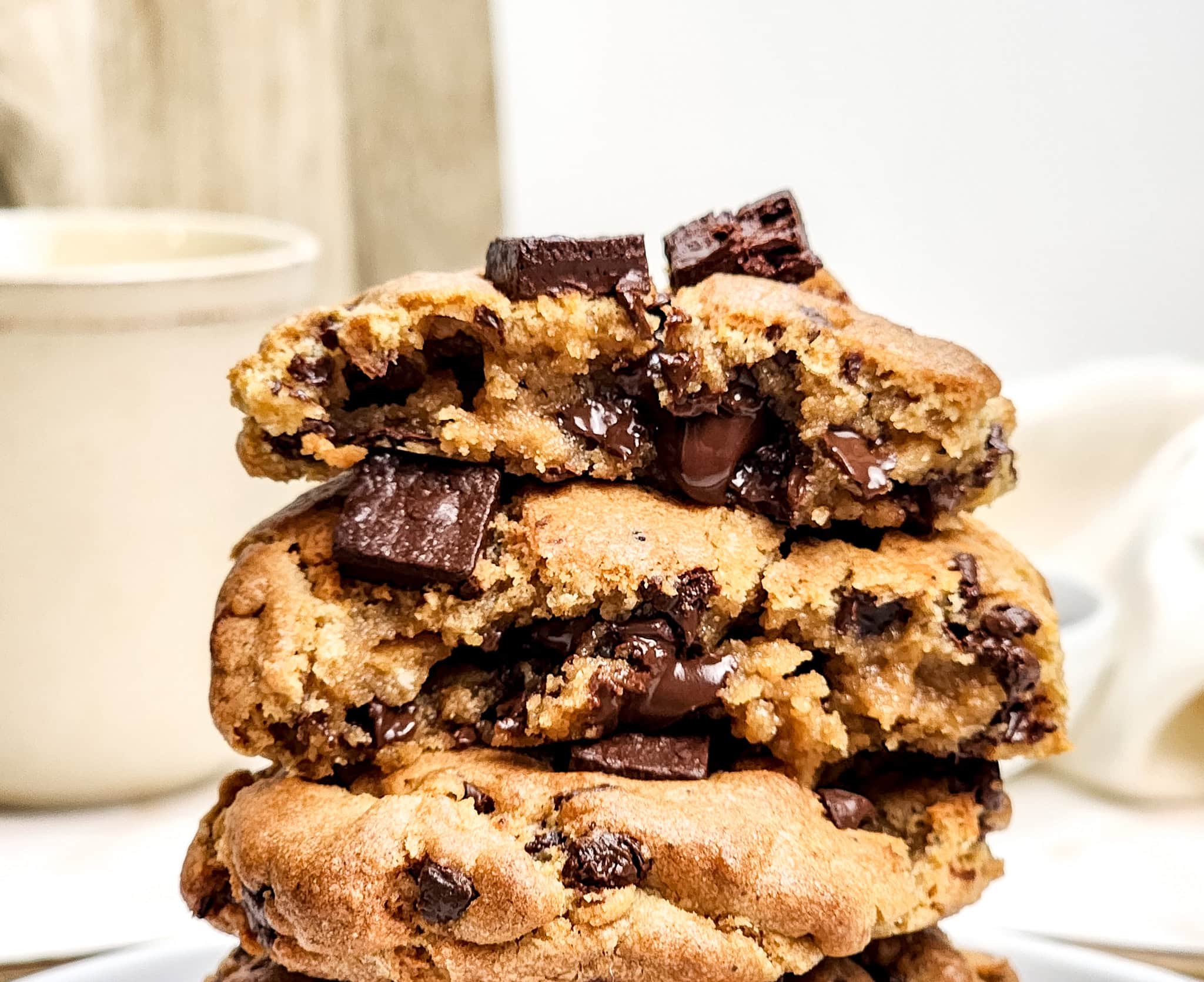 Close up of stacked cookies with the top cookie bitten and gooey chocolate.
