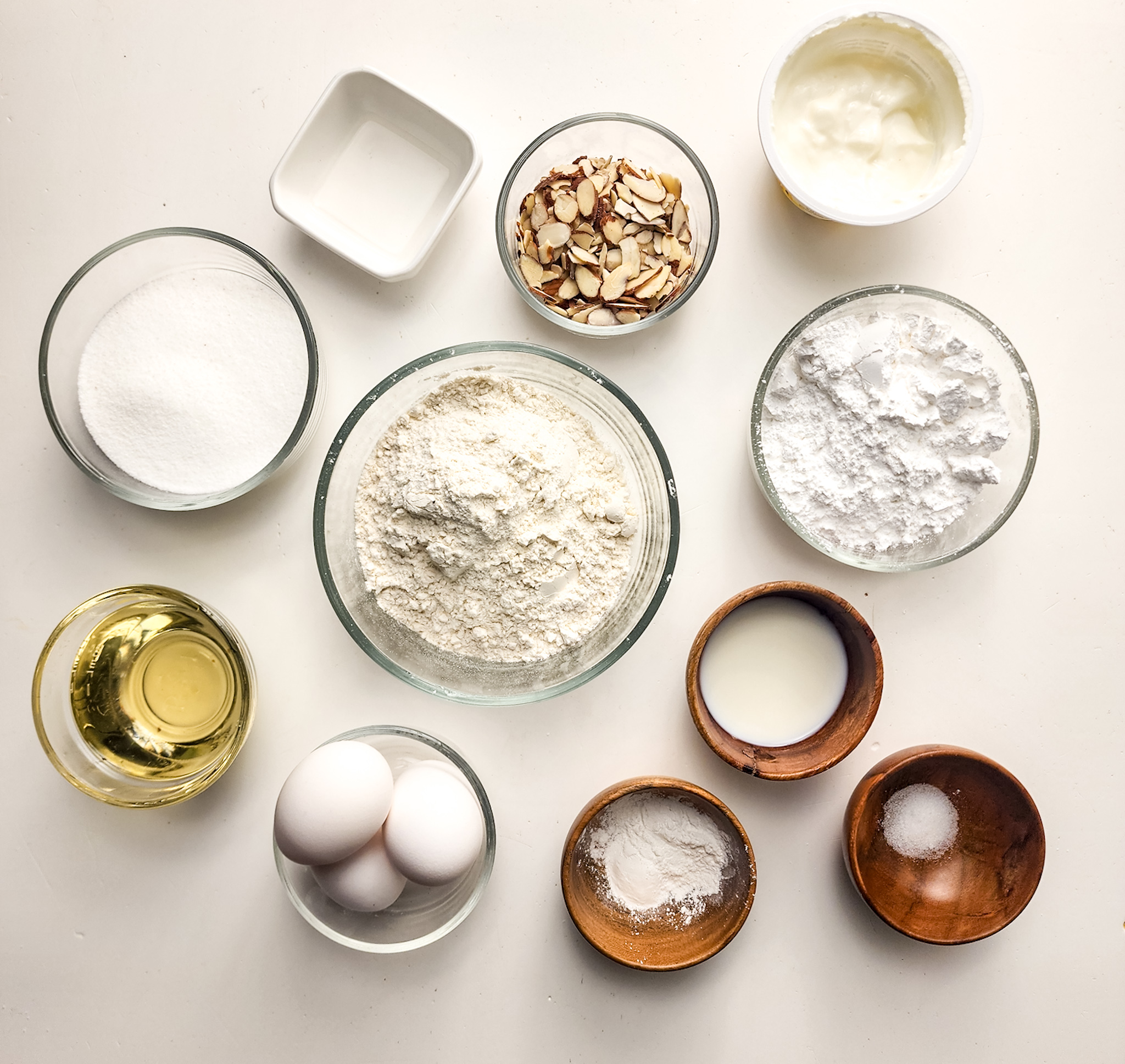 Ingredients for the  Gluten Free Greek Yogurt Almond Cake in individual glass bowls.