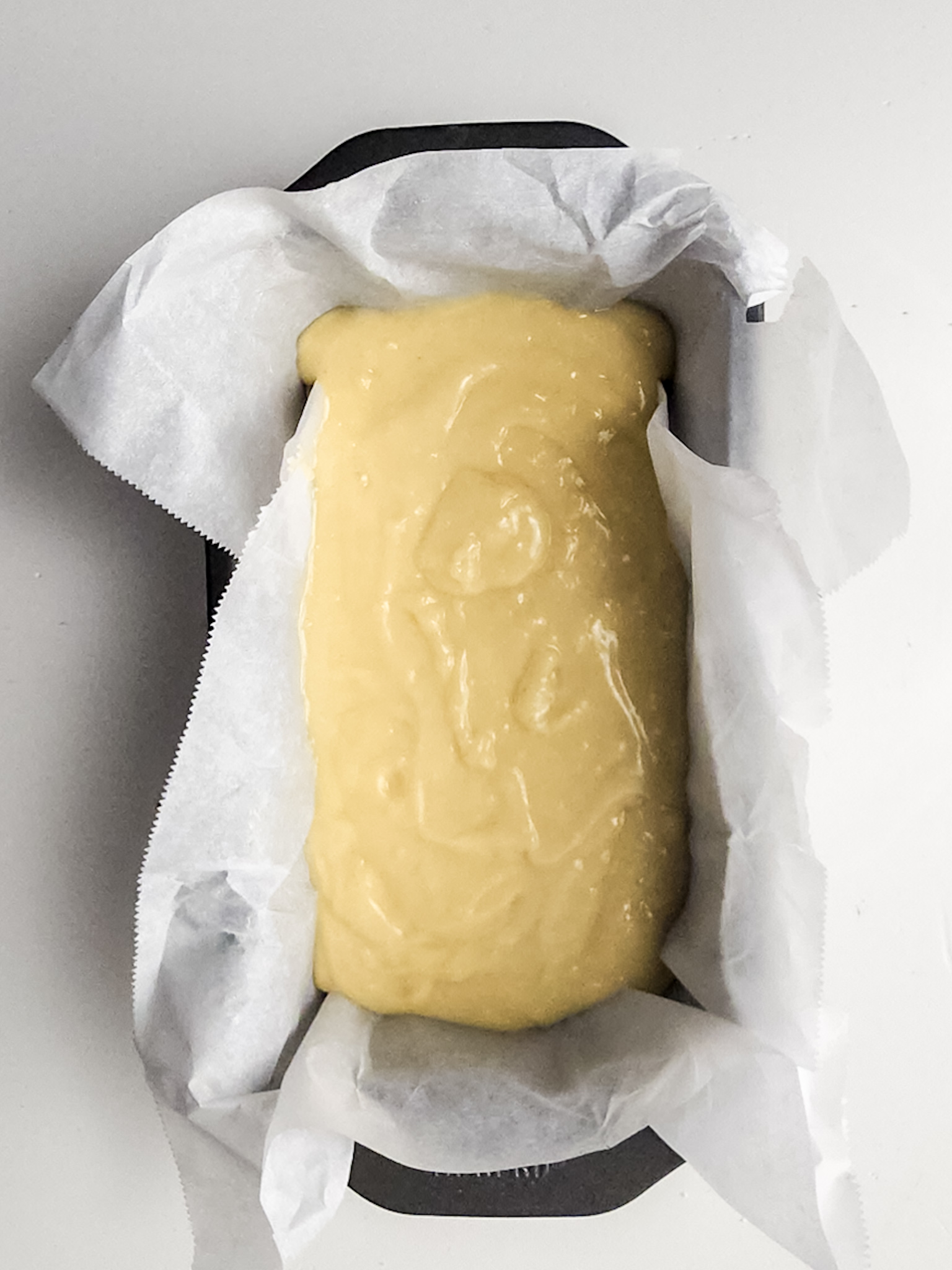 The batter poured in a parchment lined loaf pan.