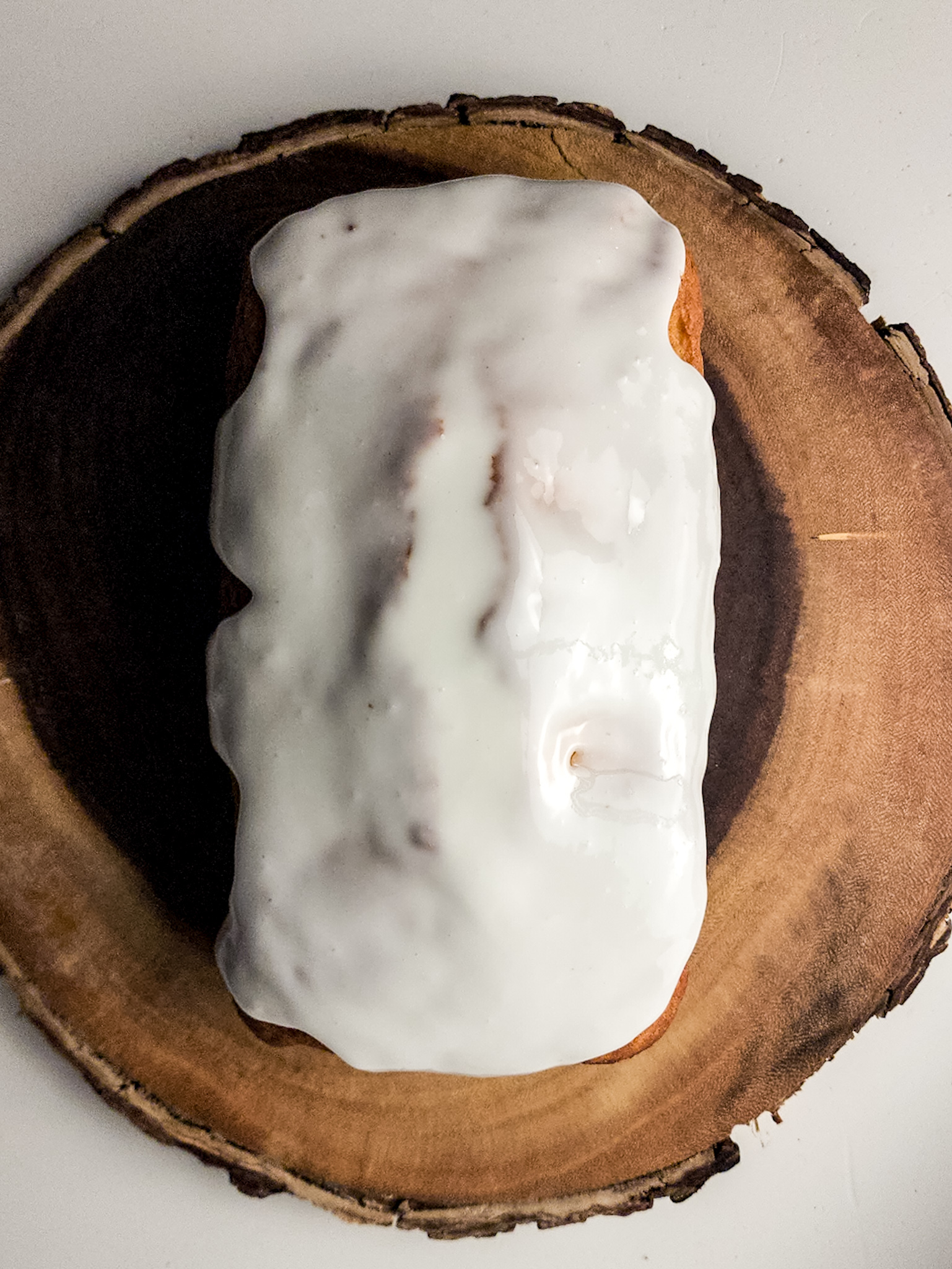 Almond glazed cake on a wood tray.