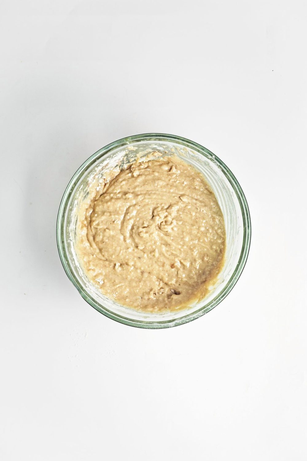 Batter for vegan apple muffins in a glass bowl.
