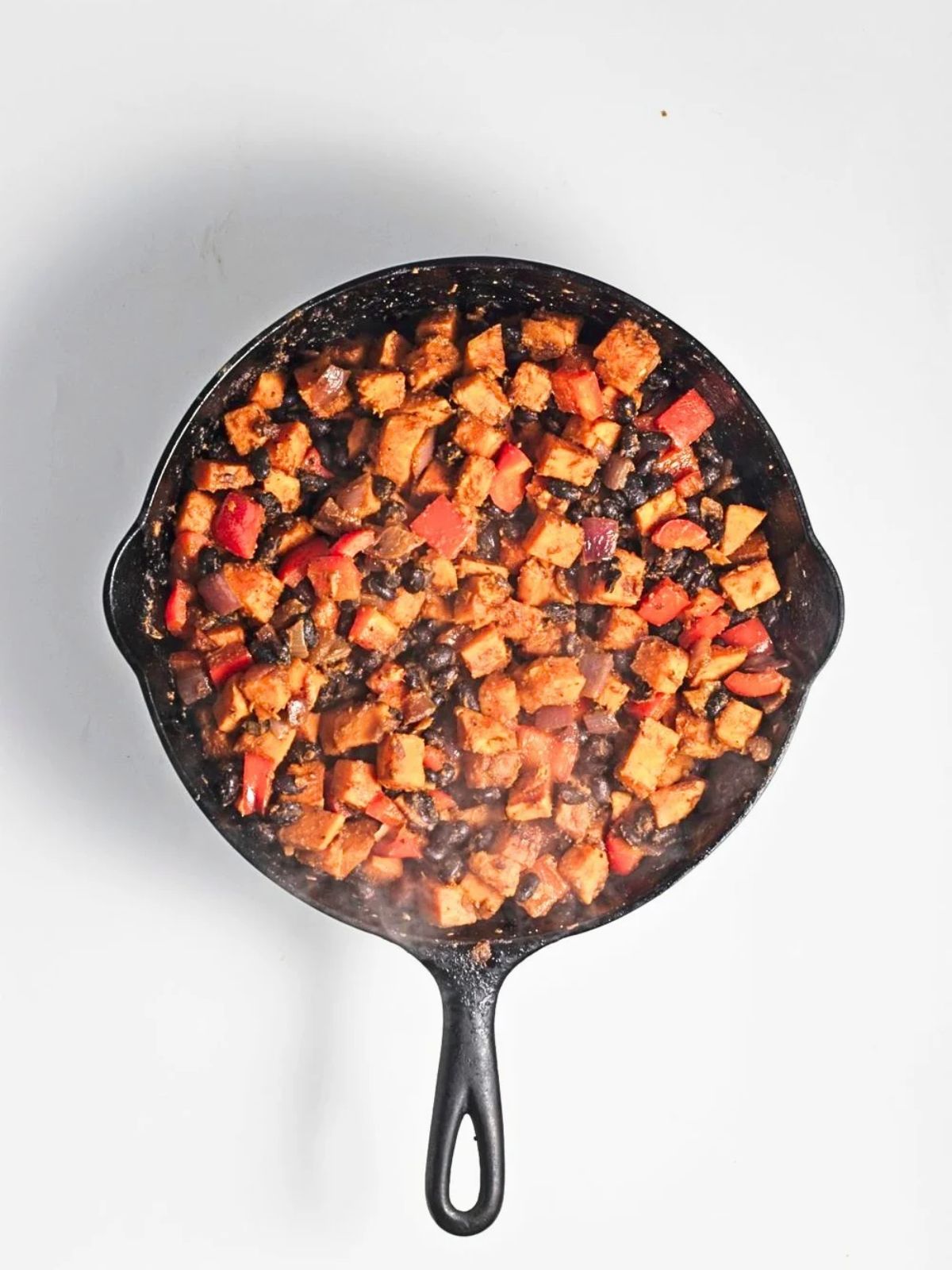Final hash all together in a cast iron skillet with browned sweet potatoes, black beans, red bell peppers and red onion.